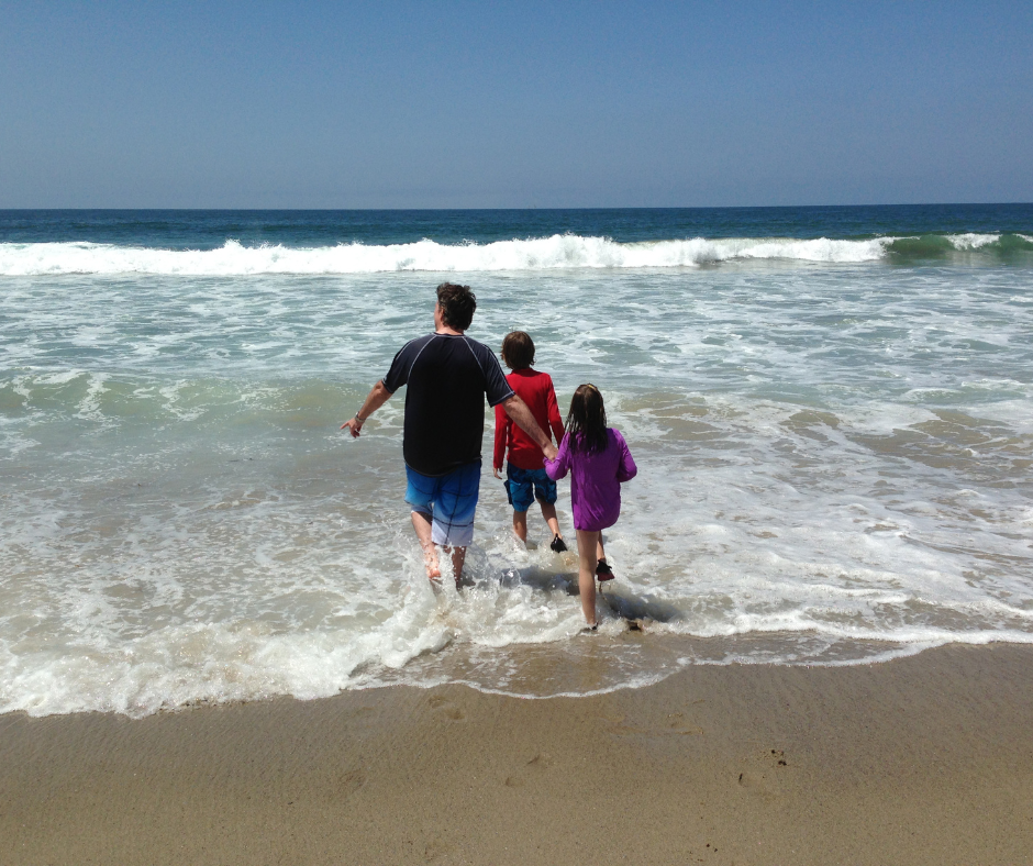 family paddling in sea in summer