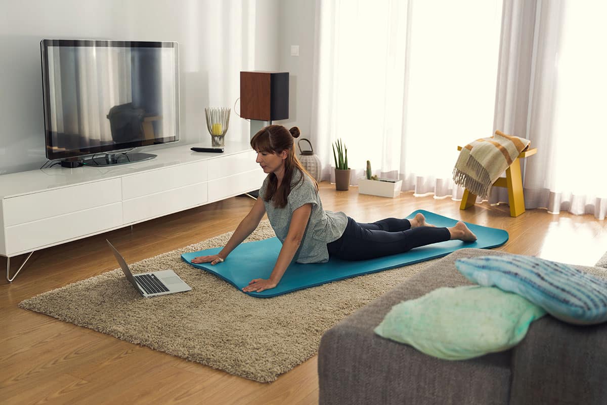 Young women exercising at home with an online fitness class