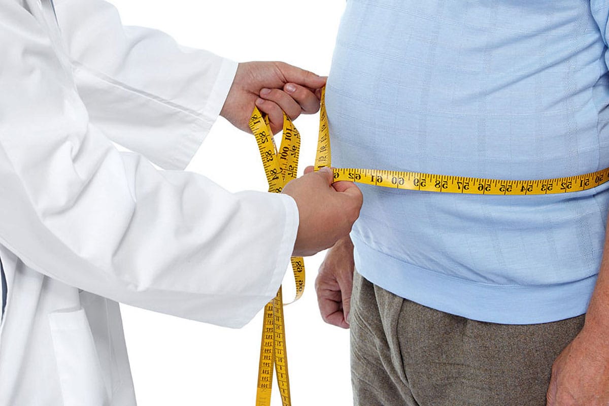 Individual taking waist measurements as part of a wellness check