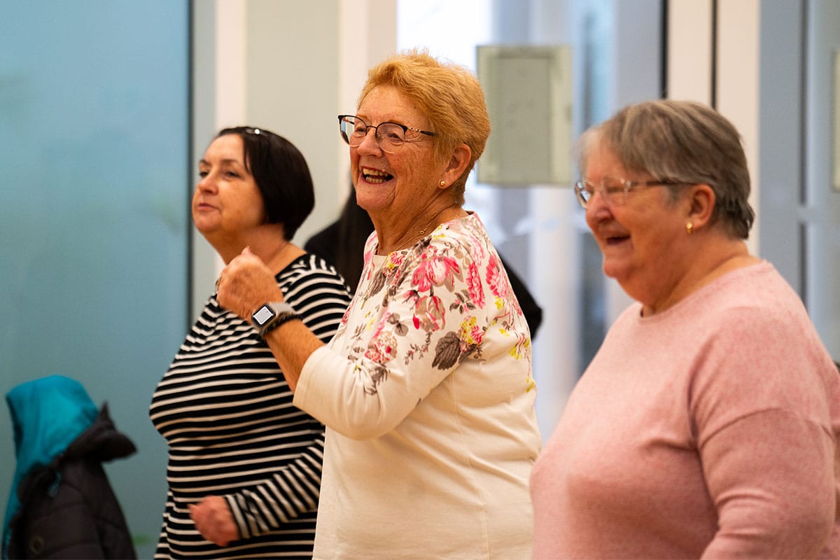Three women staying active and smiling during a workout