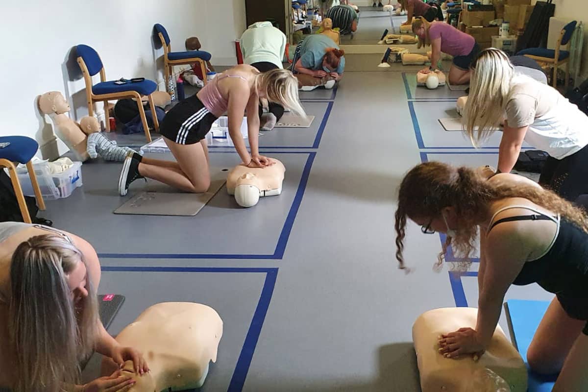 Students in a first aid course practising life-saving CPR techniques