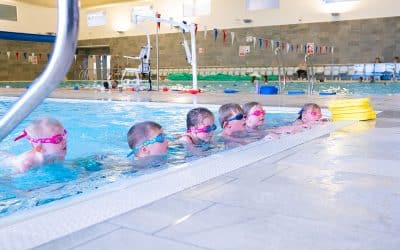 Group of children receiving a swimming lesson