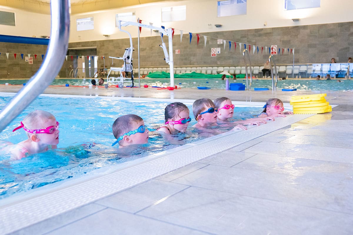 Group of children receiving a swimming lesson