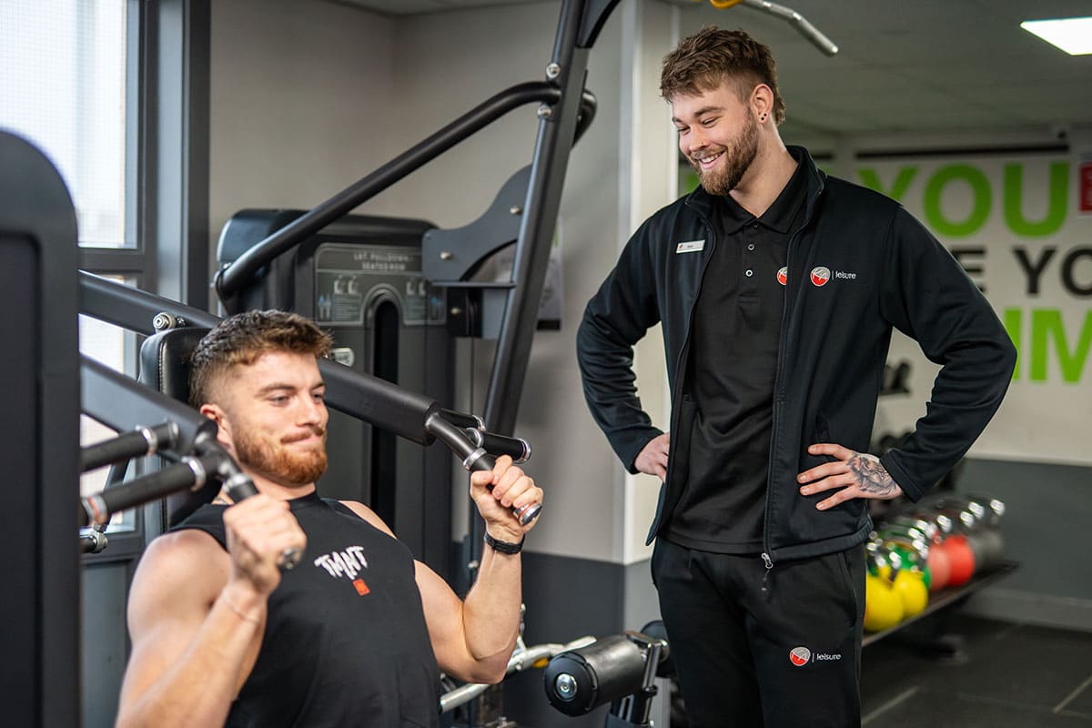 KA Leisure personal trainer enjoying showing a member how to use the equipment