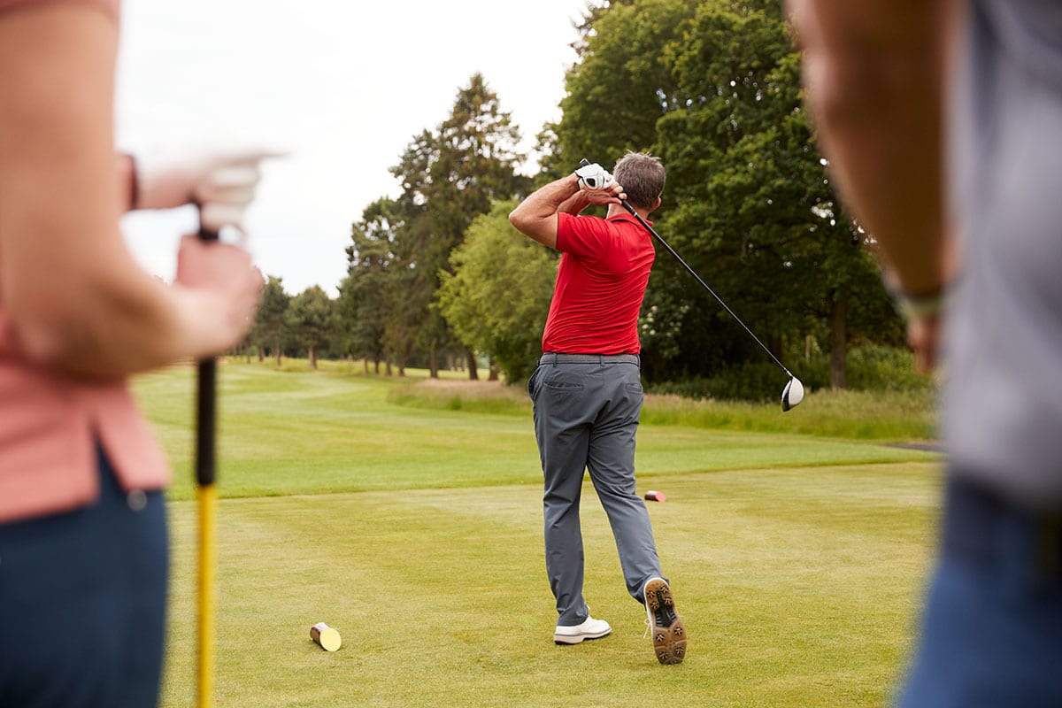 Golfer teeing off on golf course