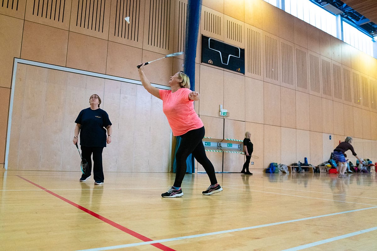 Women playing badminton in sports hall