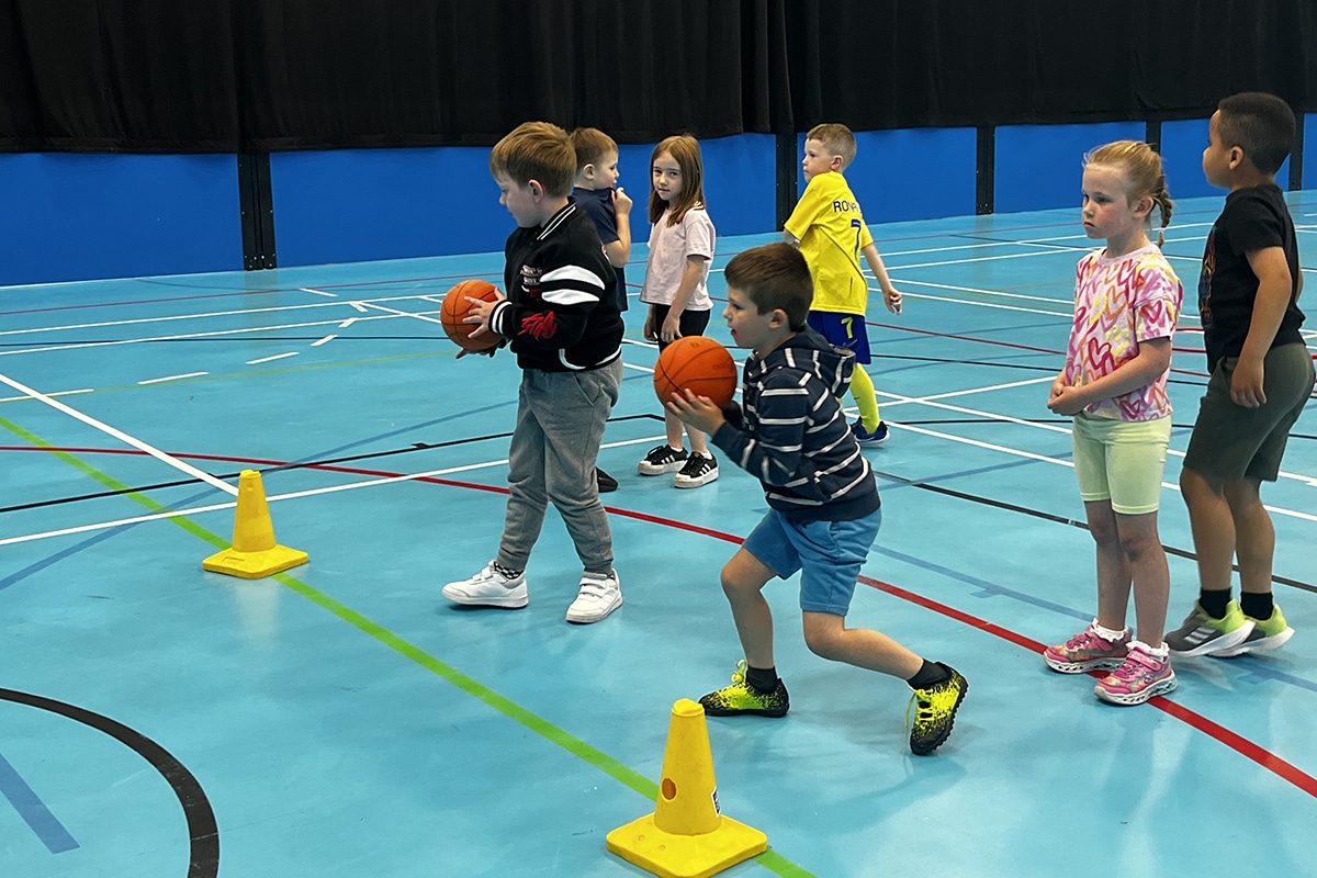 Children playing ball game in sports hall