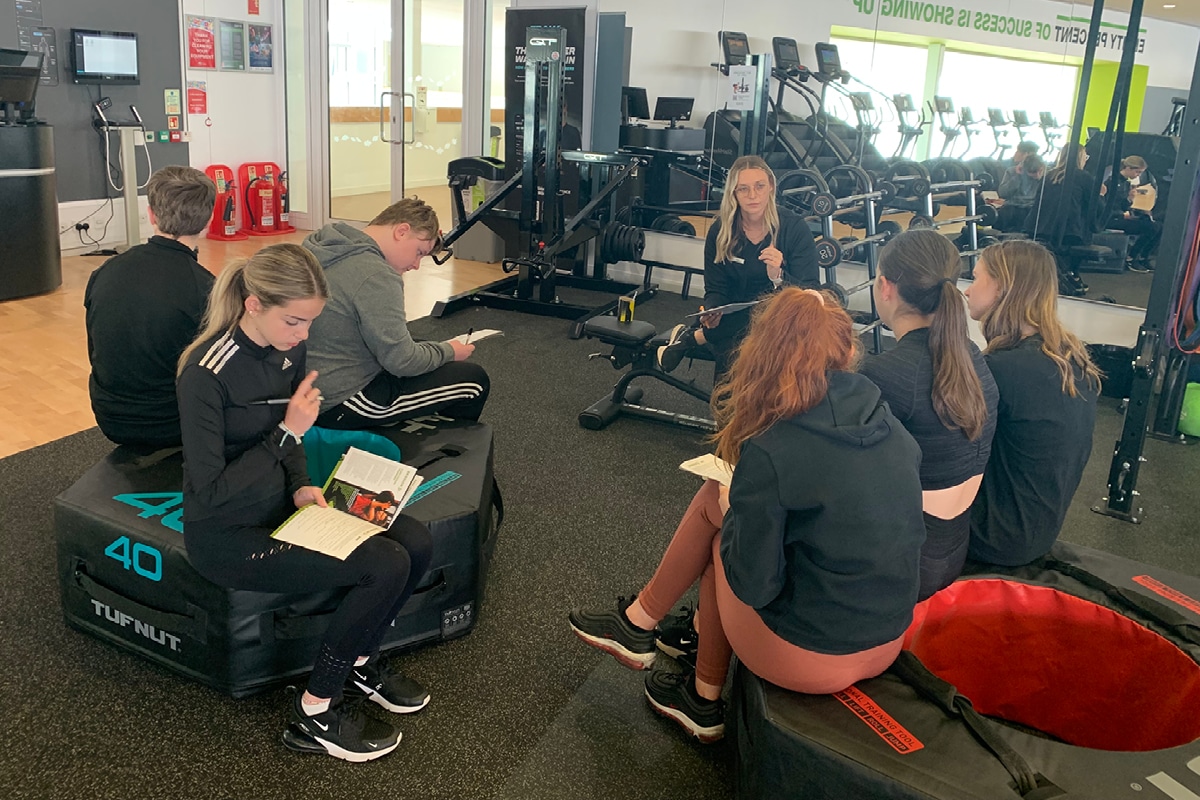 Teenagers learning about gym equipment